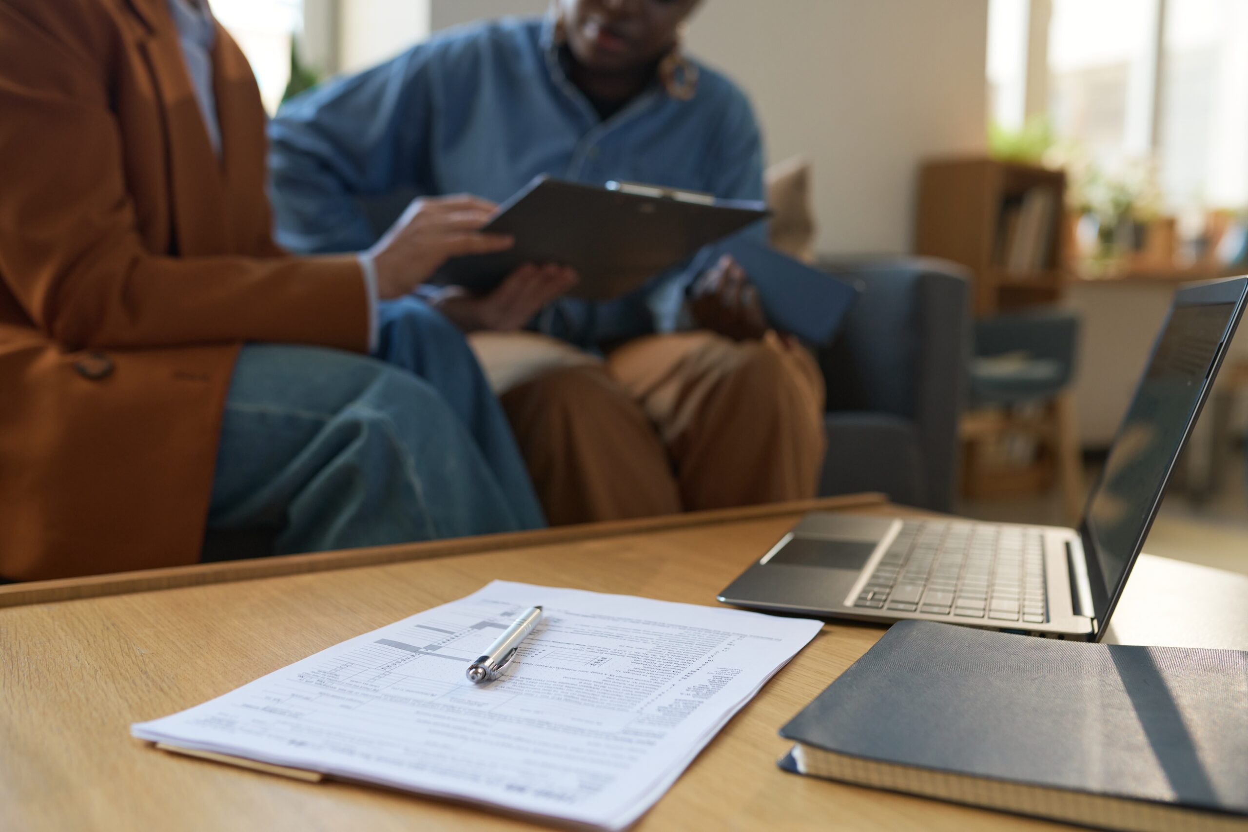 Stack of legal or business documents with a pen on a coffee table, ready for review or signing
